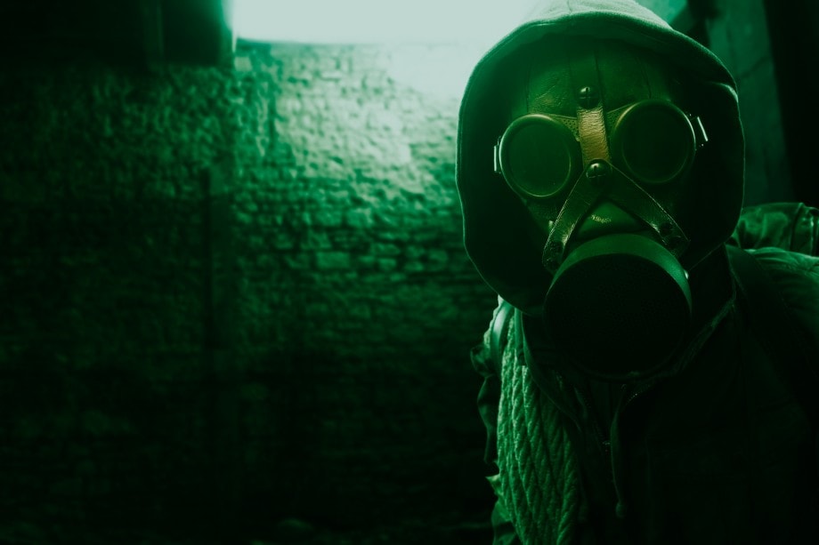post-apocalypse nuclear disaster survivor in a post apocalyptic setting, he is wearing a gas mask and walking in a destroyed city